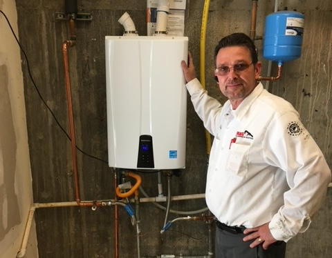 Bragg Technician Todd next to a tankless water heater